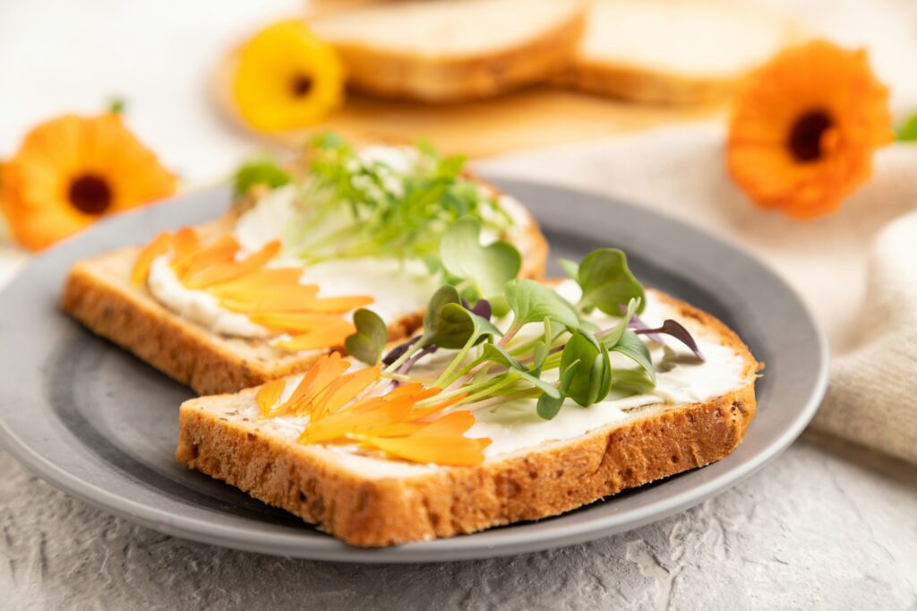 White bread sandwiches with cream cheese, calendula petals and microgreen radish